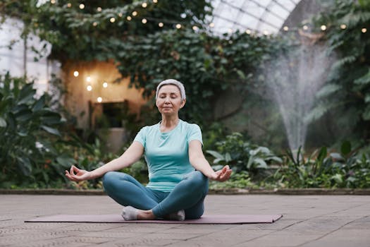 Elderly woman meditating in serene botanical garden setting, focused on wellness and mindfulness.