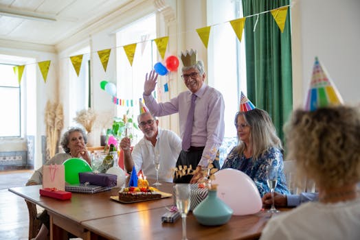 Joyful indoor birthday party for senior with friends celebrating with cake and decorations.